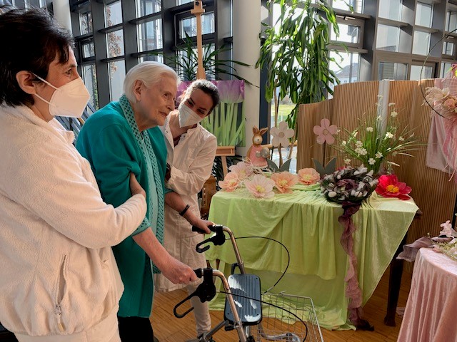 Mit Hilfe von Kathinka Siebert von der Physiotherapie-Praxis Beck & Kollegen (rechts) und Pflegerin Alma Mihmic (links) unternimmt Heim-Bewohnerin Ingeborg Wachtel ihre ersten Schritte im Caritas Altenzentrum.
