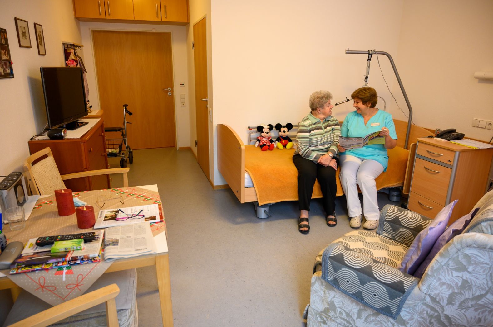 Eine Pflegerin zusammen mit einer Bewohnerin auf ihrem Zimmer