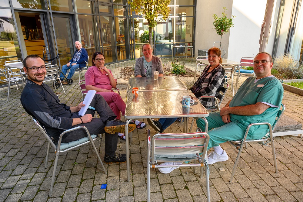 CAZ-Mitarbeiter*innen sitzen auf der Terrasse