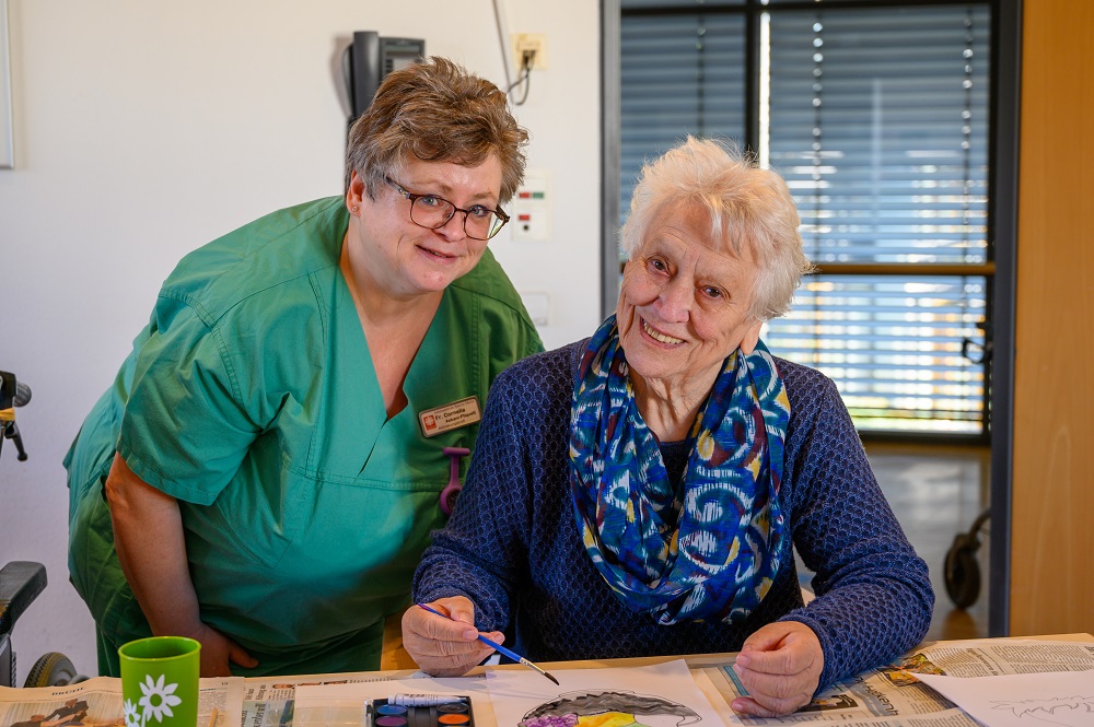Eine Bewohnerin malt ein Bild mit Wasserfarben
