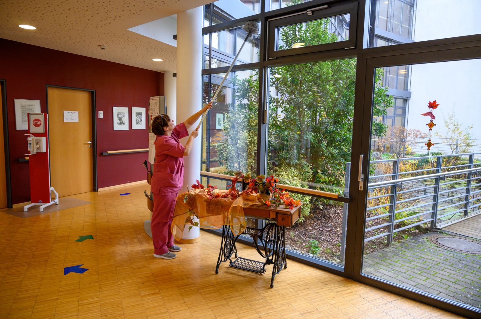 Eine Reinigungskraft säubert die Fenster