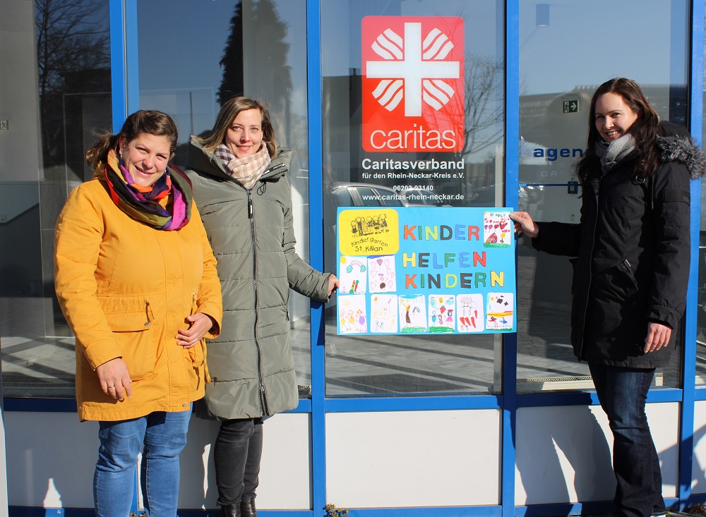 Symbolische Spendenübergabe vor dem Eingang zum Caritasverband