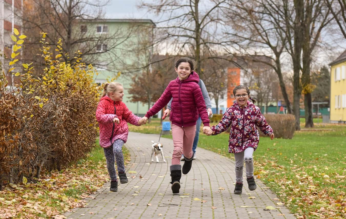 Drei Mädchen rennen lachend