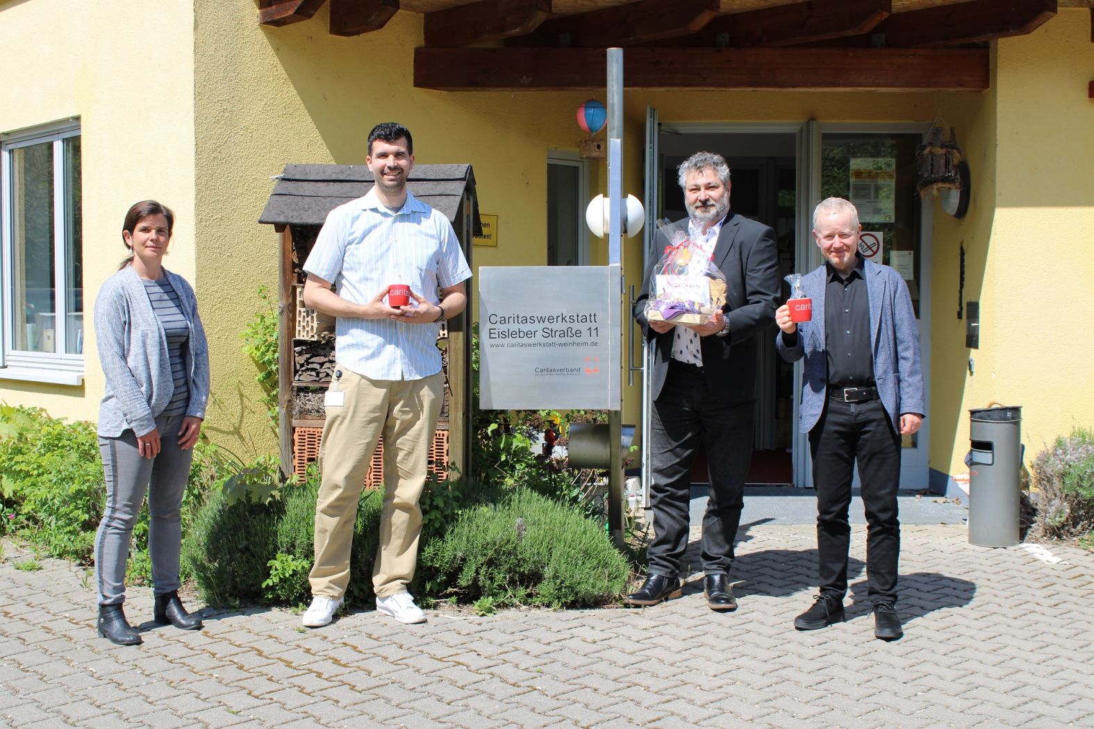 Werkstattleiterin Kathrin Hartmann, Matthias Roth, Jörg Theissing und Johannes Fayner von MLP vor der Caritaswerkstatt Weinheim