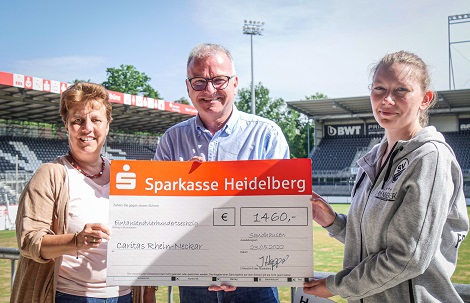 Sabine Dumat-Gehrlein und Bernhard Martin vom Caritasverband erhalten den symbolischen Scheck von Juliane Hoppart vom SV Sandhausen (Quelle: SVS)