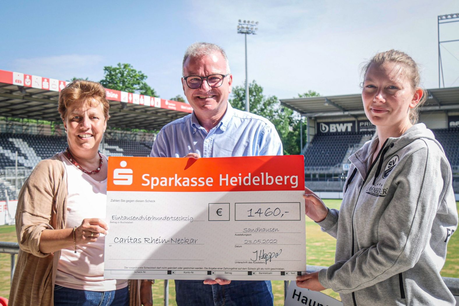 Sabine Dumat-Gehrlein und Bernhard Martin vom Caritasverband erhalten den symbolischen Scheck von Juliane Hoppart vom SV Sandhausen (Quelle: SVS)