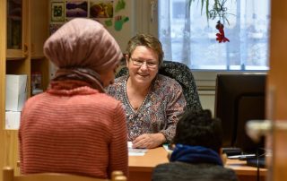 Migrationsberaterin bei der Beratung einer Frau mit Kind