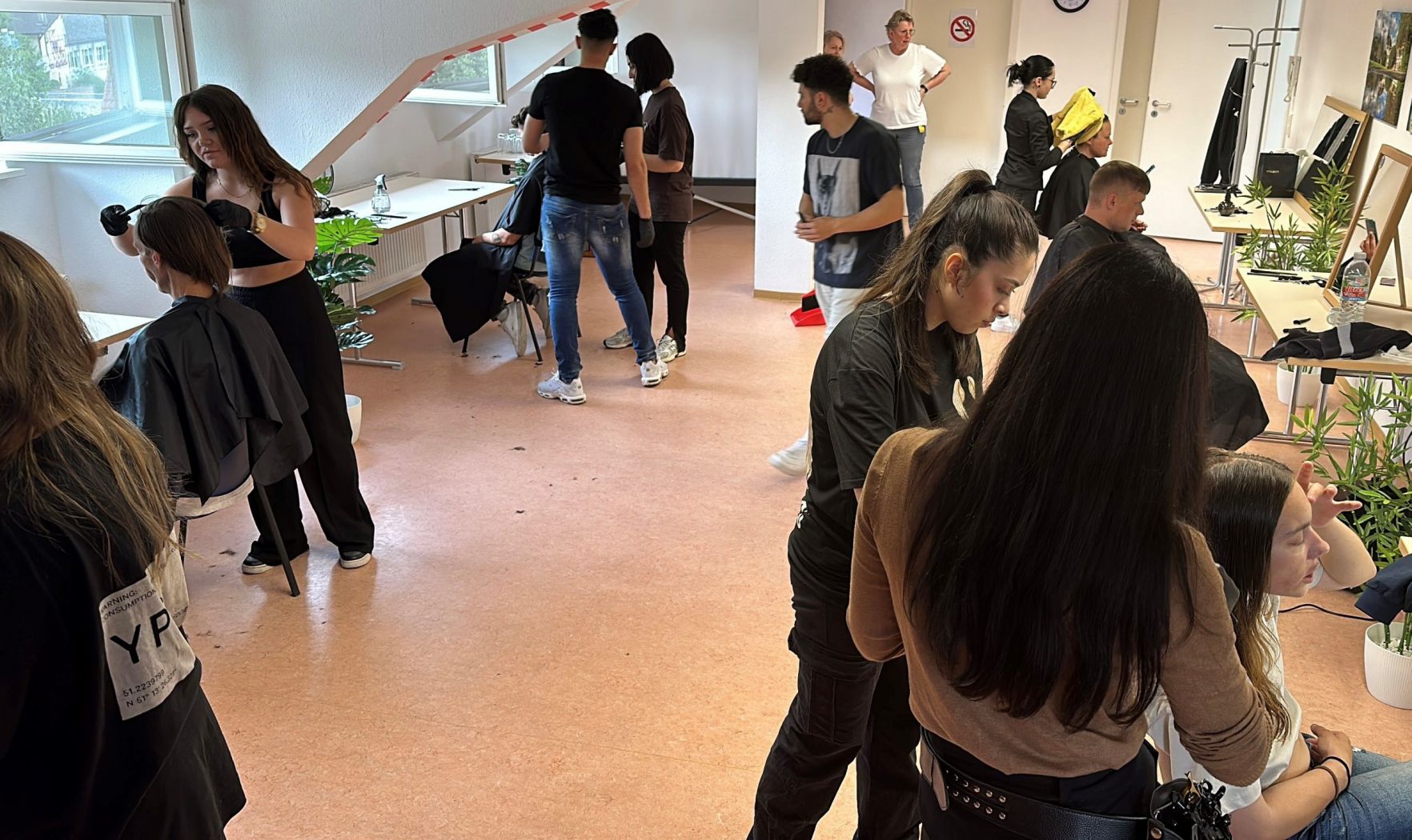 Friseurauszubildende schneiden in der Tagesstätte wohnsitzlosen Menschen ehrenamtlich die Haare