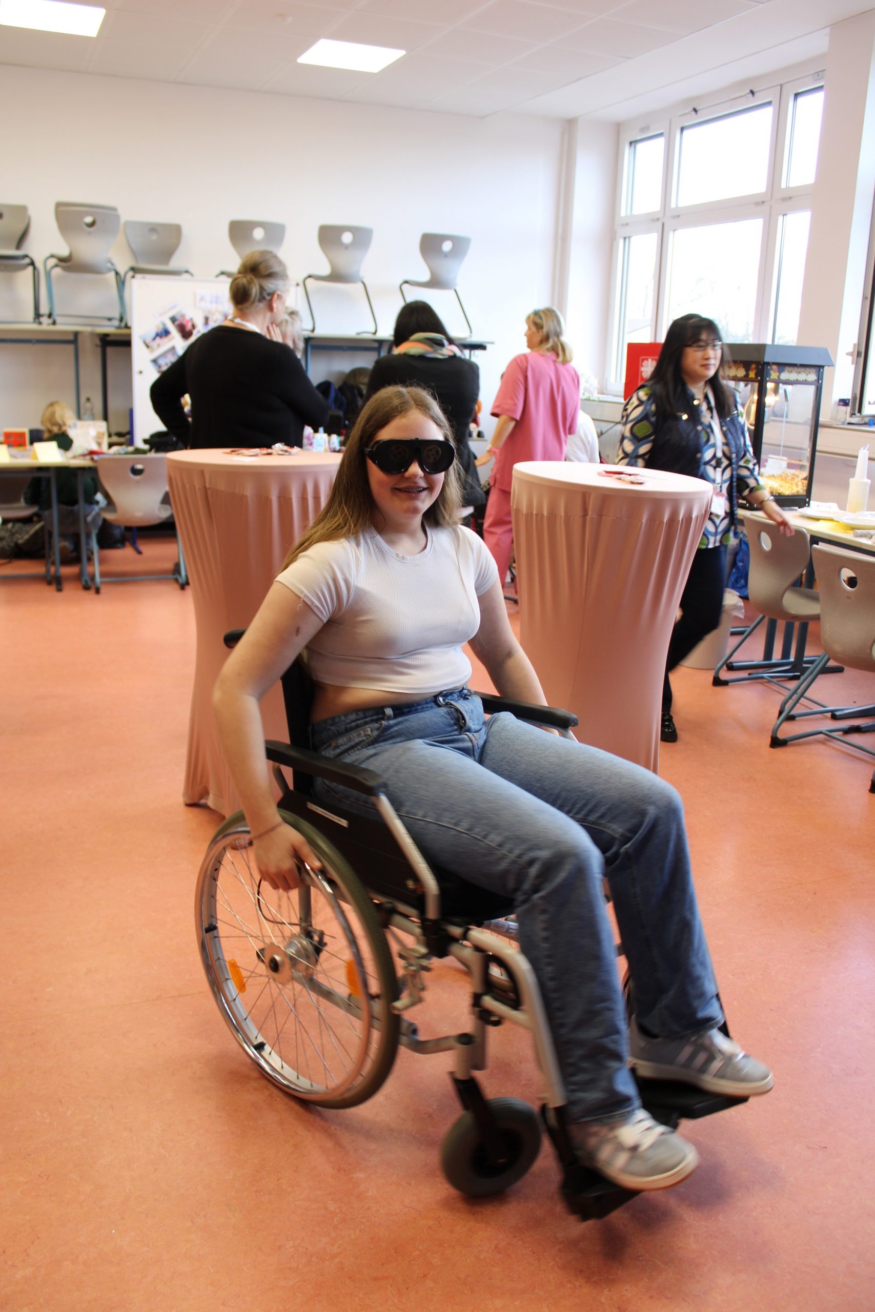 Eine Schülerin versetzt sich in die Lage eines Menschen mit Rollstuhl und Sehbehinderung