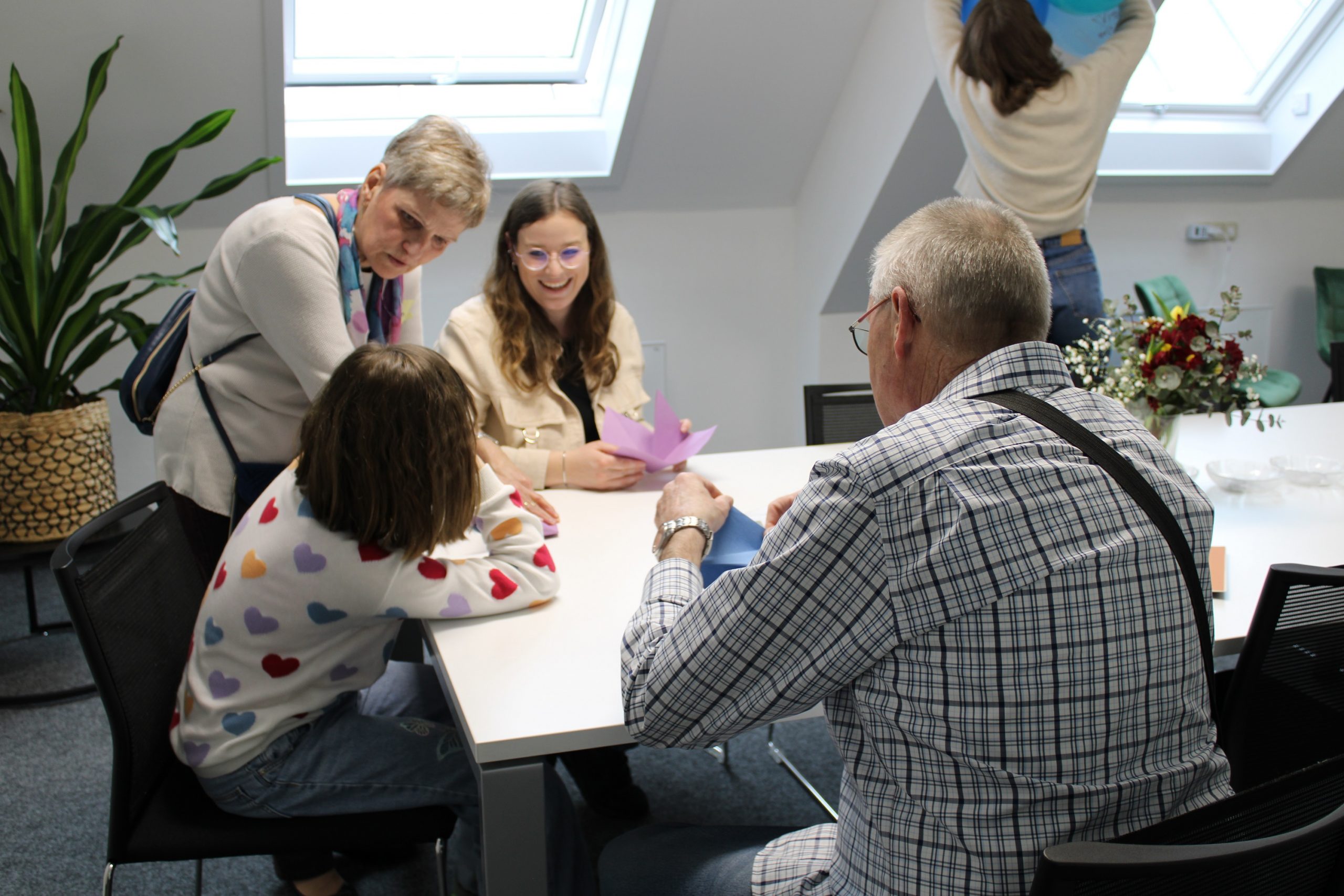 Lisa Link (Mitte) beim gemeinsamen Origami-Basteln mit einer Pflegefamilie